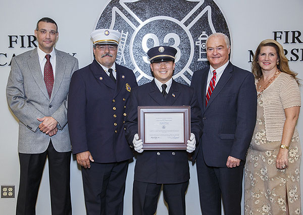 Justin Lee of the Robertsville Fire Company in Marlboro is presented with the Class 107 Ronald Fitzpatrick Firefighter 1 Award at the Monmouth County Fire Academy graduation on June 24, 2015 in Howell, NJ. Pictured left to right: Fire Academy Director Armand Guzzi, Monmouth County Fire Marshal Henry Stryker III, Justin Lee, Freeholder John P. Curley and Freeholder Deputy Director Serena DiMaso.